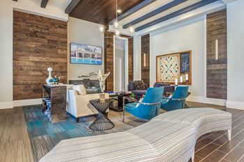 A living room with a white couch and blue chairs
